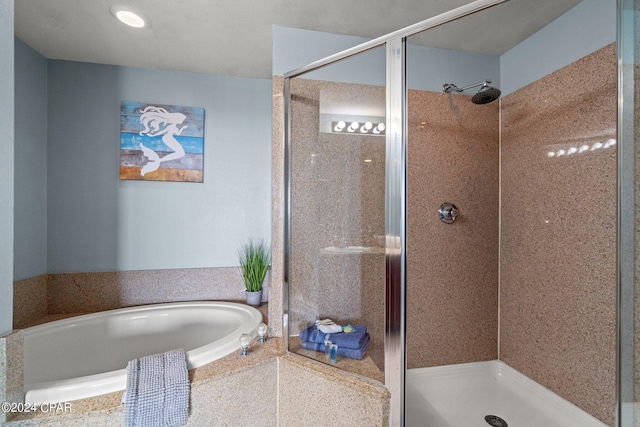 bathroom featuring a garden tub and a shower stall