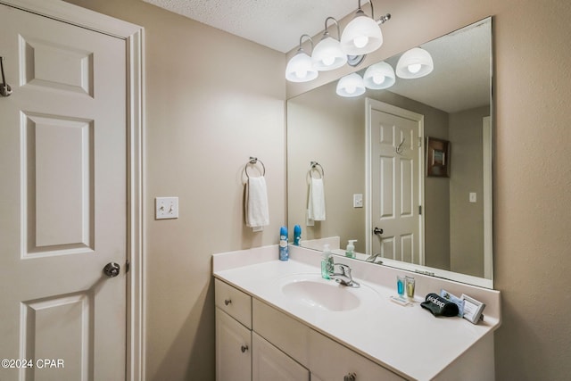 bathroom featuring a textured ceiling and large vanity