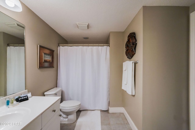 bathroom with toilet, tile floors, vanity, and a textured ceiling