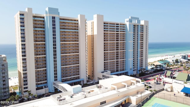 view of building exterior with a beach view and a water view