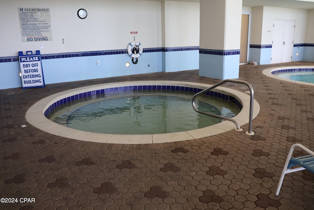 view of swimming pool with an indoor hot tub