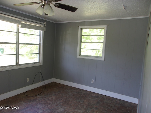 tiled spare room featuring ceiling fan, a healthy amount of sunlight, crown molding, and a textured ceiling