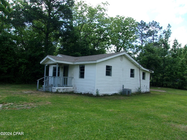 view of front of property with a porch, central AC, and a front lawn