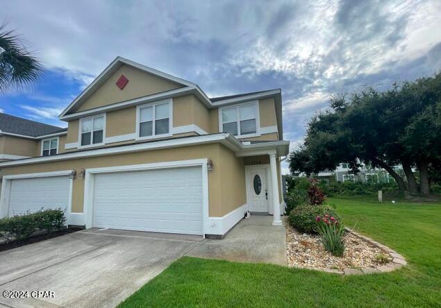 front of property with a garage and a front lawn