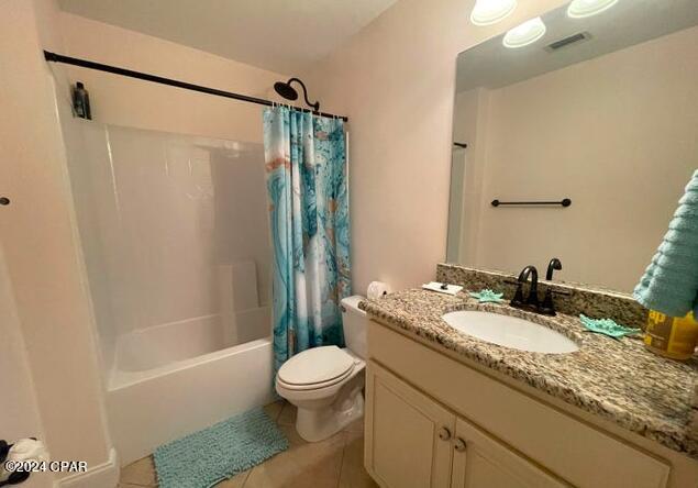 full bathroom with vanity, shower / tub combo, tile patterned flooring, and toilet