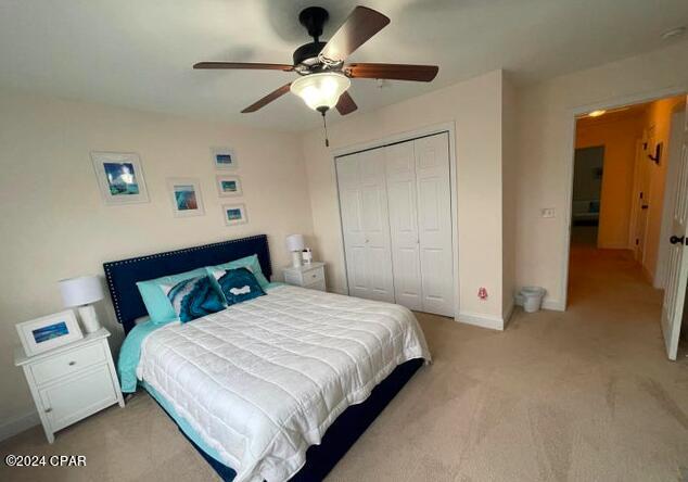 bedroom with light carpet, a closet, and ceiling fan