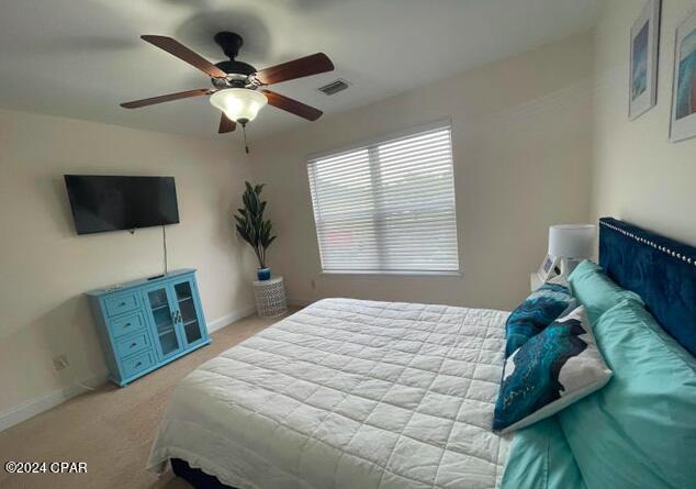 bedroom with ceiling fan and light colored carpet