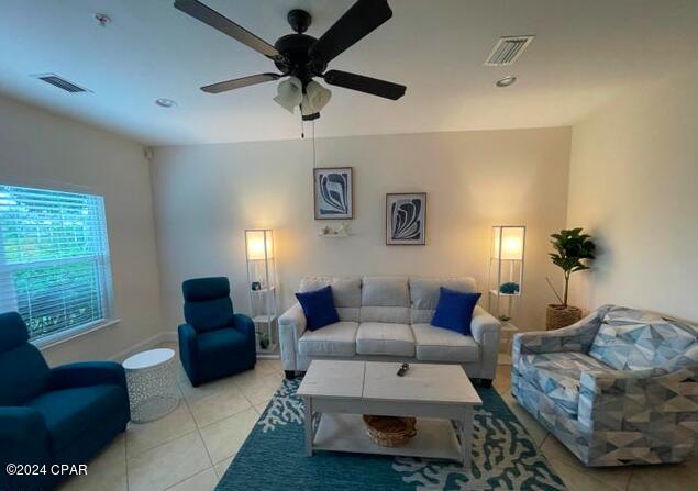 living room with ceiling fan and light tile patterned flooring