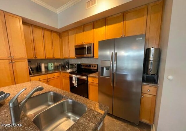 kitchen featuring appliances with stainless steel finishes, dark stone counters, ornamental molding, sink, and backsplash