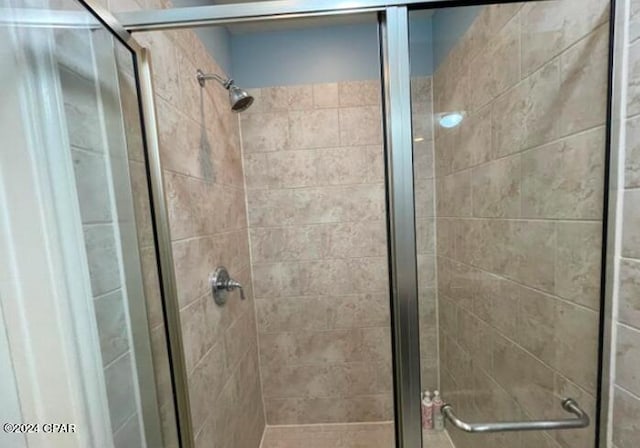 bathroom with a shower with door