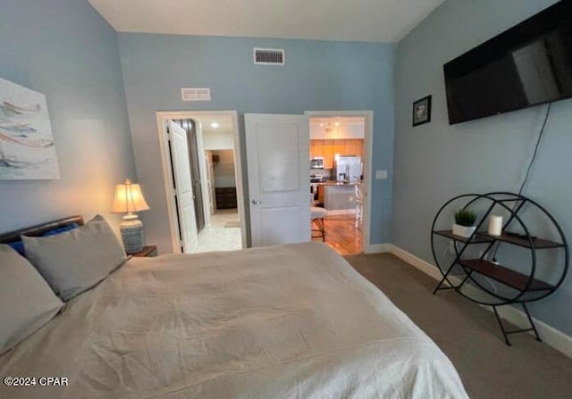 bedroom with white refrigerator with ice dispenser and carpet