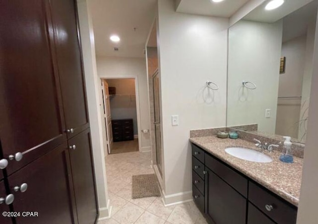 bathroom featuring tile patterned floors, vanity, and a shower with shower door