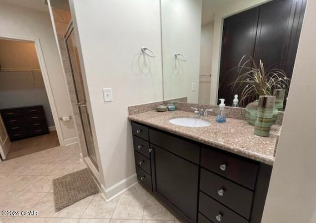 bathroom with tile patterned flooring, vanity, and a shower with shower door