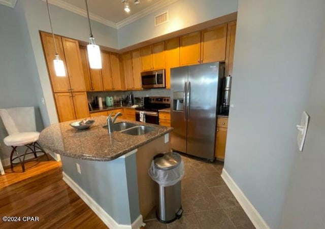 kitchen with dark stone countertops, a kitchen island with sink, stainless steel appliances, a breakfast bar, and sink