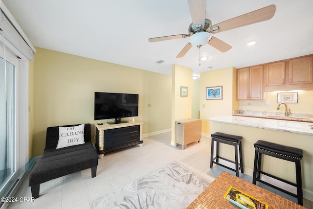 living room with sink, ceiling fan, and light tile patterned floors