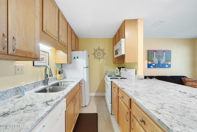 kitchen featuring white appliances, light stone countertops, light tile patterned floors, and sink