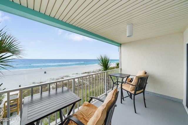 balcony with a beach view and a water view