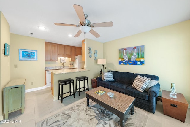 tiled living room with sink and ceiling fan