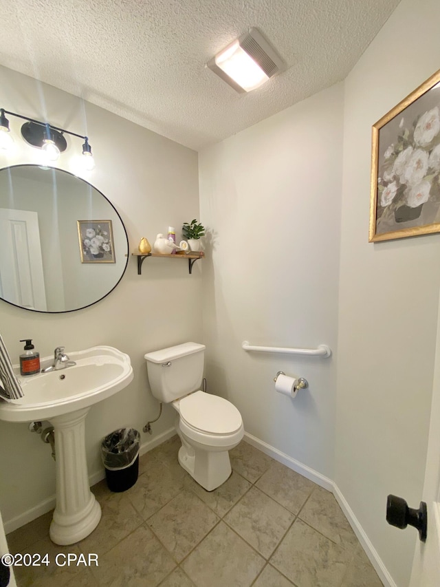 bathroom with tile patterned floors, a textured ceiling, and toilet