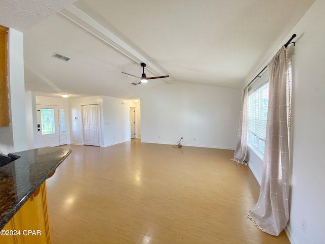 unfurnished living room featuring ceiling fan, light wood-type flooring, and vaulted ceiling