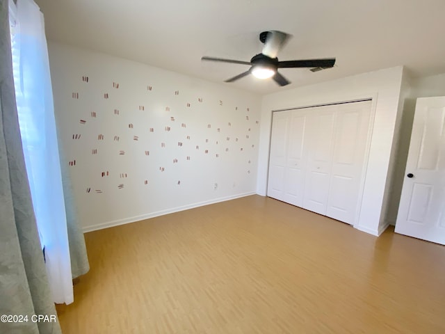 unfurnished bedroom with a closet, ceiling fan, and hardwood / wood-style floors