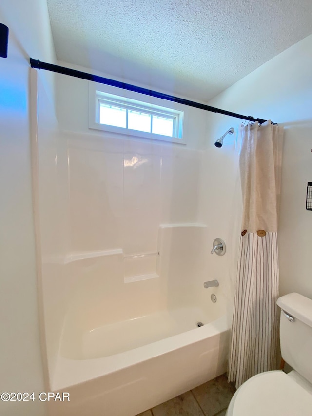 bathroom featuring tile patterned floors, shower / tub combo, a textured ceiling, and toilet