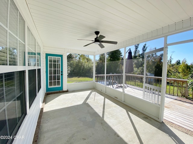 unfurnished sunroom featuring ceiling fan and plenty of natural light