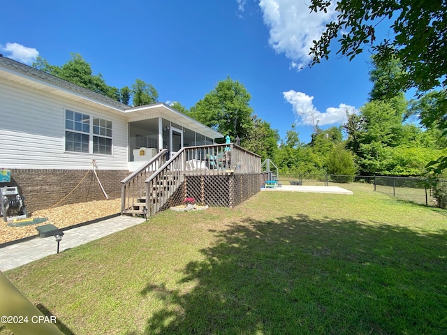 view of yard with a sunroom and a wooden deck