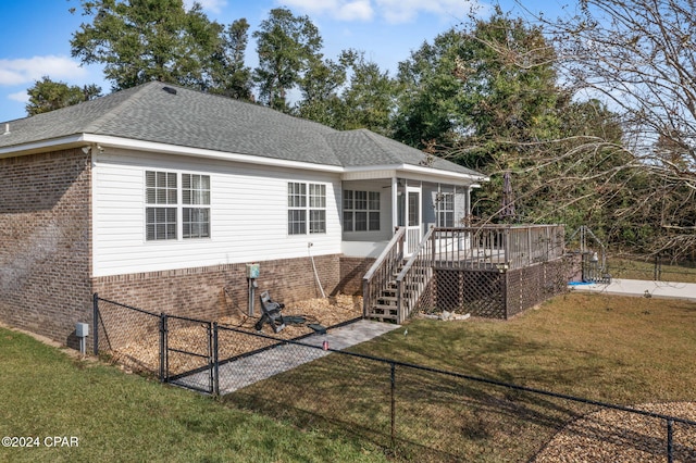 view of front of home with a sunroom, a front yard, and a deck