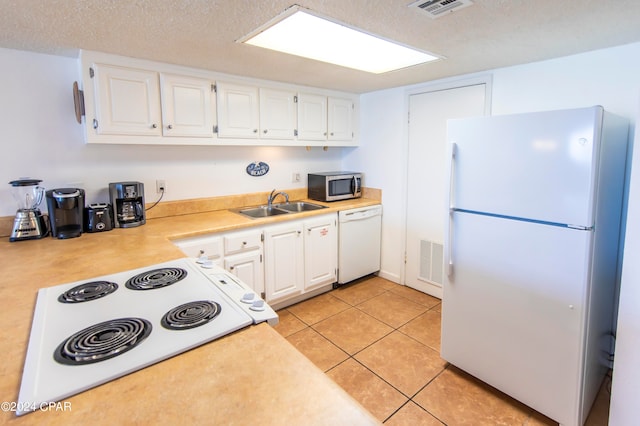 kitchen featuring white appliances, sink, white cabinetry, and a textured ceiling