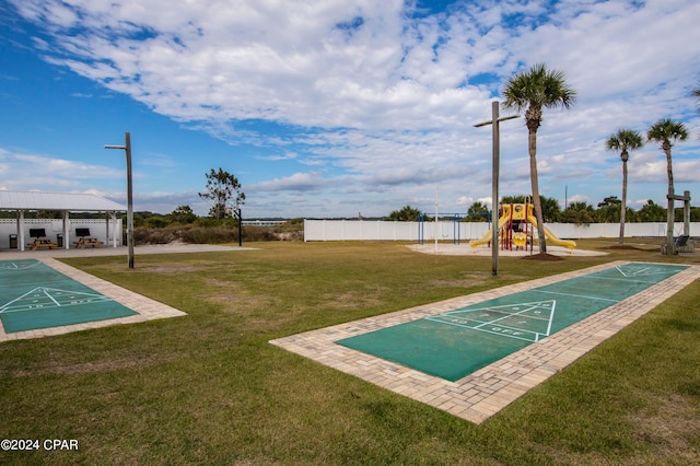 view of property's community with a playground and a yard