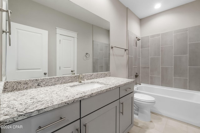 full bathroom featuring tile floors, vanity, tiled shower / bath combo, and toilet