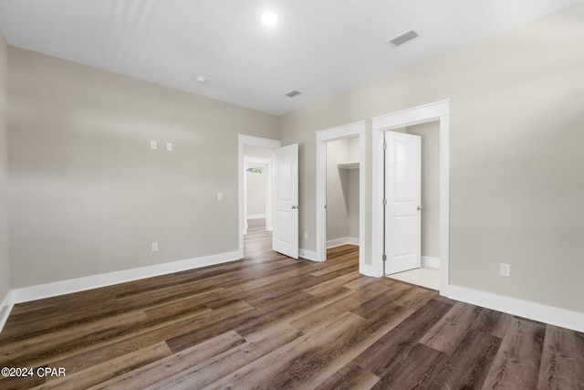 unfurnished bedroom featuring dark hardwood / wood-style flooring and a closet