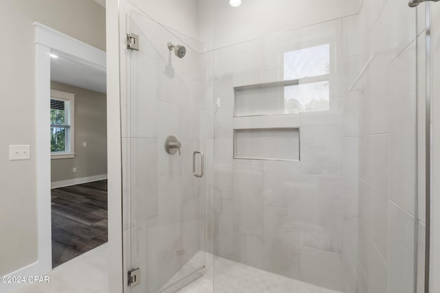 bathroom featuring walk in shower and wood-type flooring