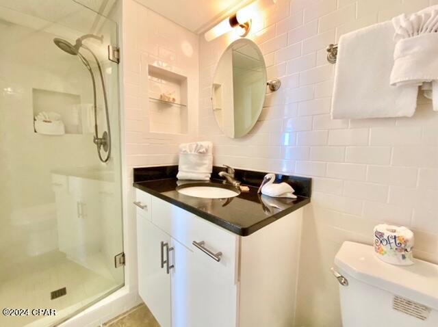 bathroom featuring an enclosed shower, vanity, and toilet