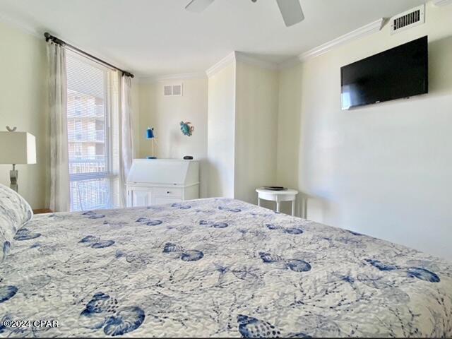 bedroom with ceiling fan and crown molding