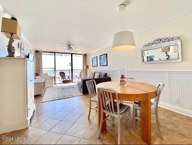 tiled dining area with ornamental molding and ceiling fan