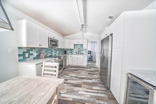 kitchen with wine cooler, lofted ceiling with beams, sink, white cabinetry, and appliances with stainless steel finishes