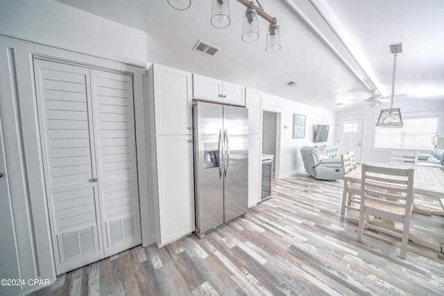 kitchen featuring stainless steel refrigerator with ice dispenser, ceiling fan, decorative light fixtures, vaulted ceiling with beams, and white cabinets