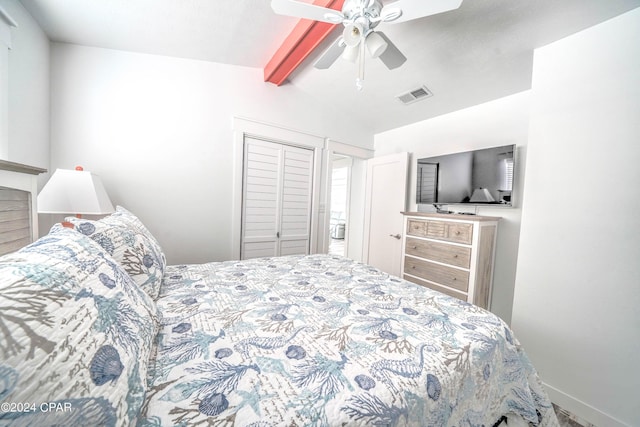 bedroom featuring ceiling fan, vaulted ceiling with beams, and a closet