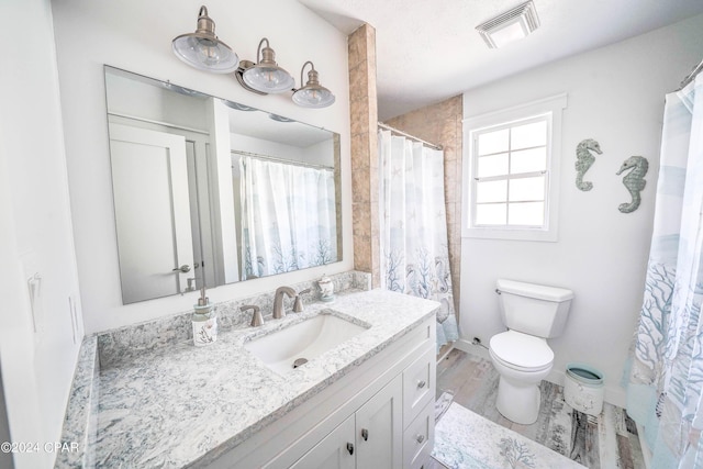 bathroom with hardwood / wood-style flooring, toilet, and vanity