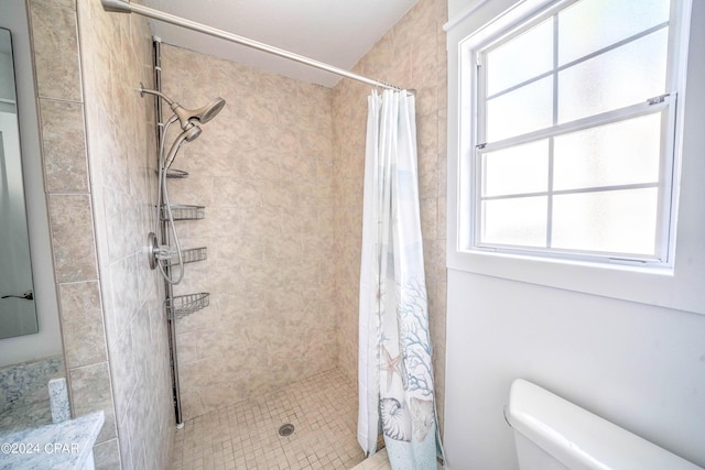 bathroom with toilet and a shower with curtain