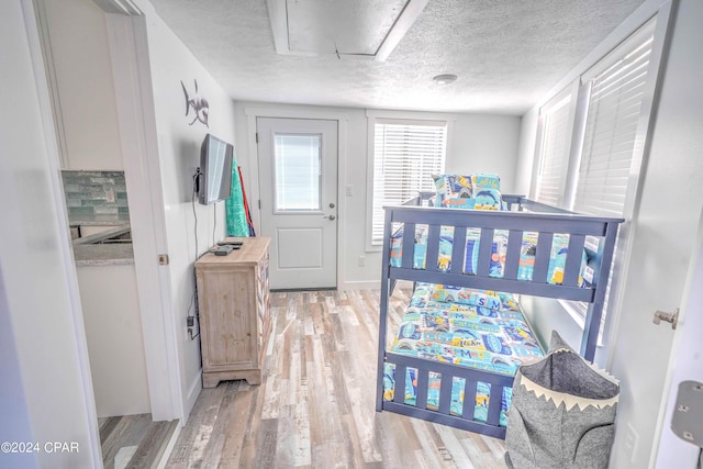 bedroom featuring a textured ceiling and light hardwood / wood-style flooring