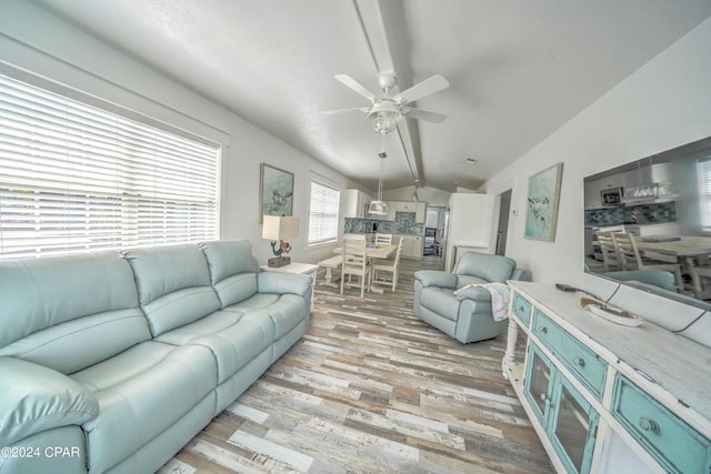 living room featuring ceiling fan, vaulted ceiling, and light wood-type flooring