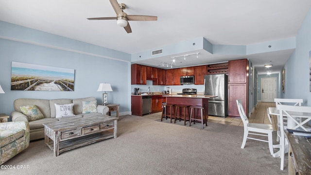 carpeted living room featuring ceiling fan, sink, and rail lighting