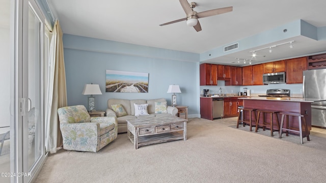 living room with light carpet, rail lighting, and ceiling fan