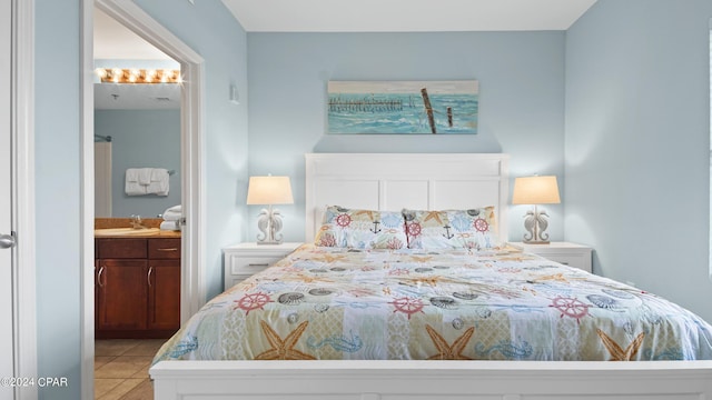 bedroom with ensuite bathroom and light tile patterned floors