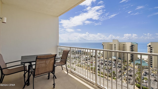 balcony with a water view and a view of the beach