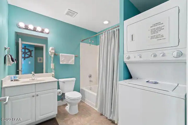 full bathroom featuring tile flooring, stacked washer and clothes dryer, shower / bath combo, toilet, and vanity