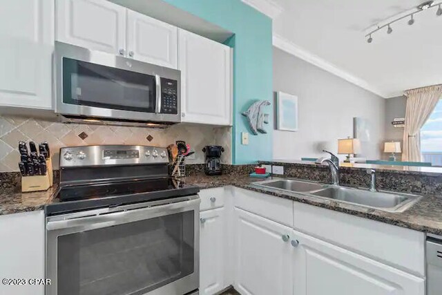 kitchen featuring dark stone countertops, stainless steel appliances, white cabinetry, and sink